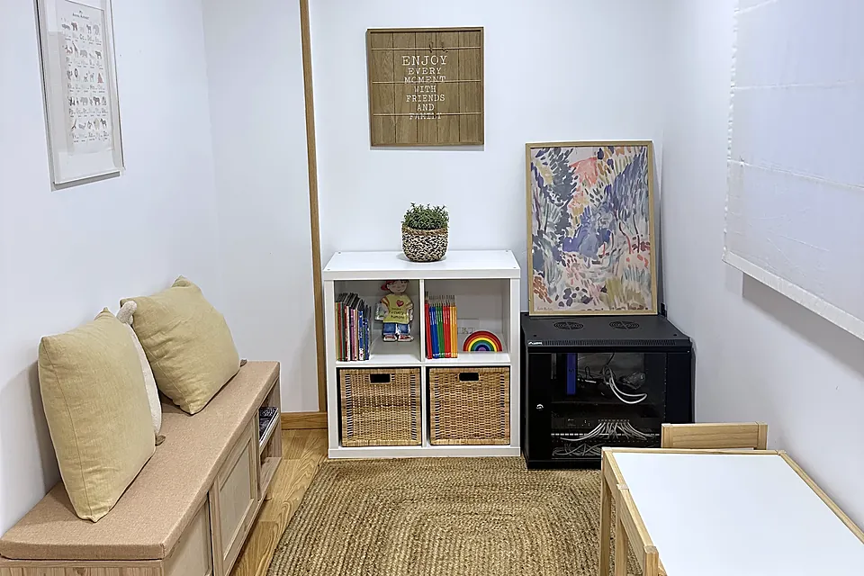Rincón de juego con banco de madera, alfombra de yute y mesa baja