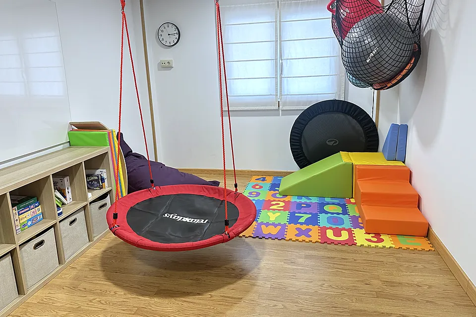 La sala de terapia ocupacional y fisioterapia, con columpio nido y material de psicomotricidad