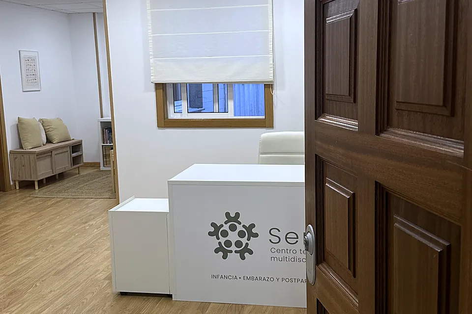 Puerta de madera abierta hacia la recepción de Serea