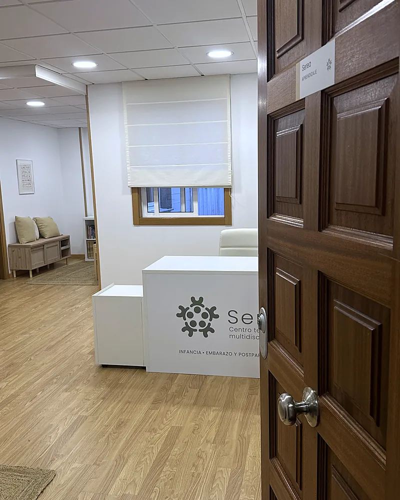 Puerta de madera abierta hacia la recepción de Serea