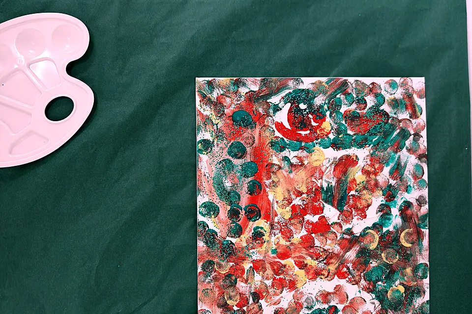 Cuadro de topos rojos, verdes y amarillos pintado en el taller de inauguración, junto a los botes de pintura