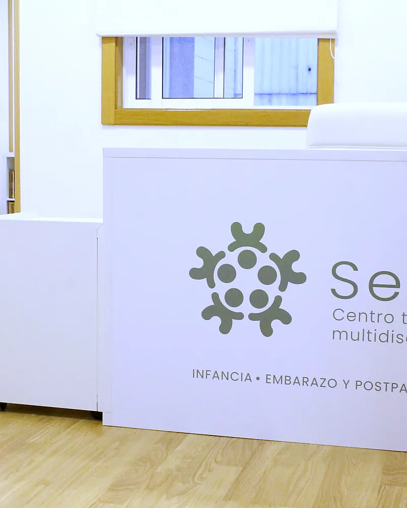 Mostrador de recepción con el logotipo de Serea y el banco de espera al fondo